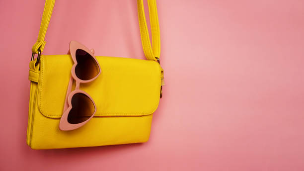 istock Yellow bag and heart-shaped sunglasses on pink background 1282172973