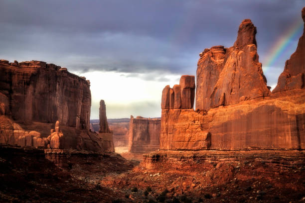 Rainbow comes after a rain storm over Park Ave area of Arches National Park located outside of Moab Utah