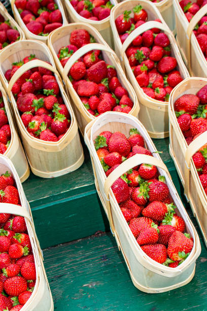 Fresh strawberries in wooden baskets at farmer's market. stock photo