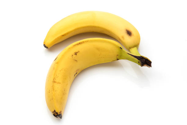 Two old banana with some spots, on a white isolated background. stock photo