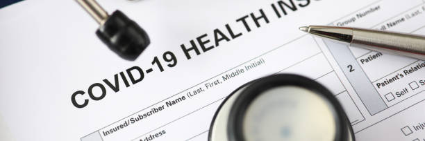 istock Silver pen lying at covid-19 insurance claim blank 1282188650