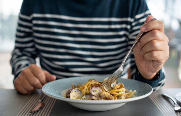 detail male hand eating pasta spaghetti with clams and mullet, mediterranean food - food dinner prepared fish gourmet imagens e fotografias de stock