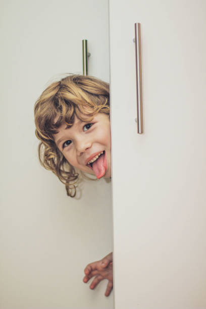 Little boy hiding in the closet stock photo stock photo