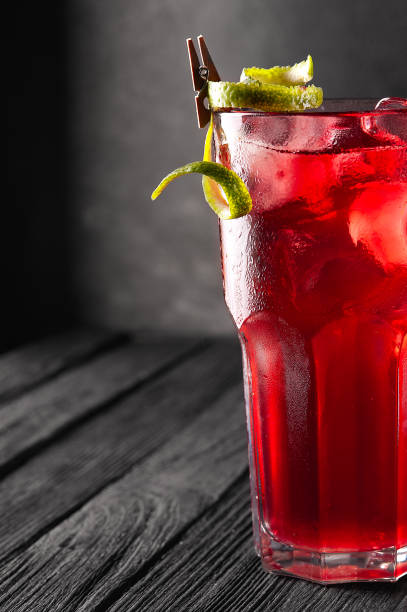 istock Alcoholic, non-alcoholic red cocktail with ice on black wooden table. 1282191876