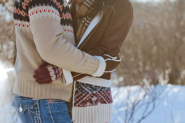 istock A man and a woman in warm sweaters hold hands on a winter walk. 1282192146