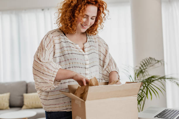 istock Young woman unpack the package she ordered online 1282194597