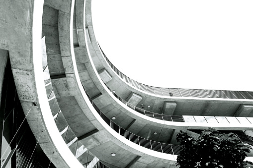 Black and white low angle view of modern round building, background with copy space, full frame horizontal composition