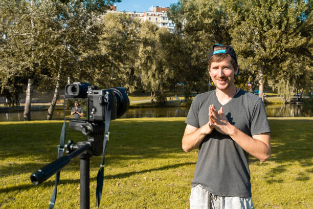 istock Young happy hipster blogger recording vlogging on digital camera in park, confident young guy, leading blogger. Business coach, freelancer, lifestyle. 1282199316