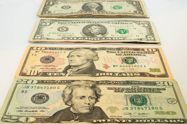 close-up of different values of US dollars arranged on a white surface