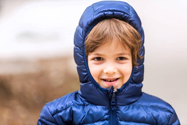 istock smiling little boy looking at the camera wearing a winter coat 1282201471