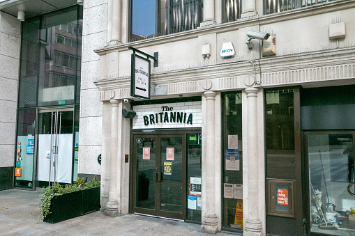 The Britannia Pub in Monument Street, London. This is a downstairs pub right next to the Monument to the Great Fire of London. Security alarms and other brand names are visible.