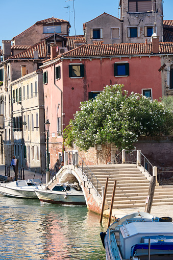 VENICE, ITALY - SEPTEMBER 21, 2020: Romantic old houses and pedestrian bridge across canal. Hardly anybody outdoors. Tourists are returning to Venice, but far fewer than in recent years.
