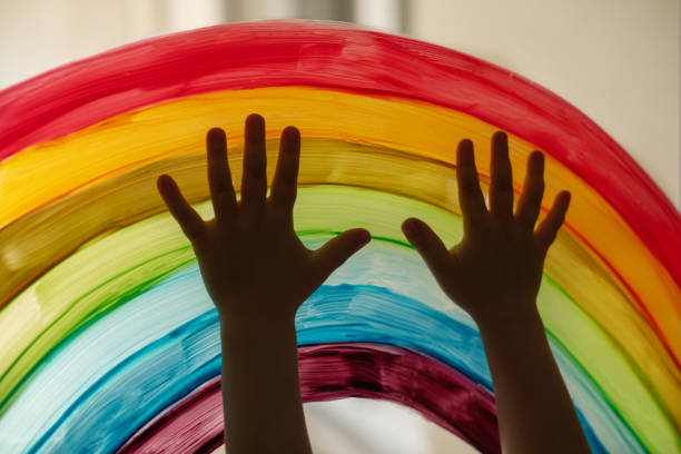 istock Child's hands touch painting rainbow on the window 1282205222
