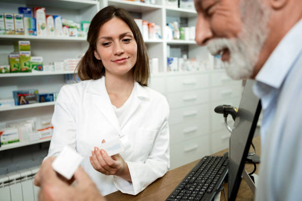 istock Female pharmacist giving medications to senior customer 1282207221