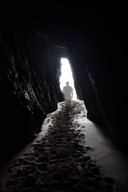 uma figura fantasmagórica transparente caminha em direção à luz no fim de um túnel. - spirituality light tunnel light at the end of the tunnel - fotografias e filmes do acervo