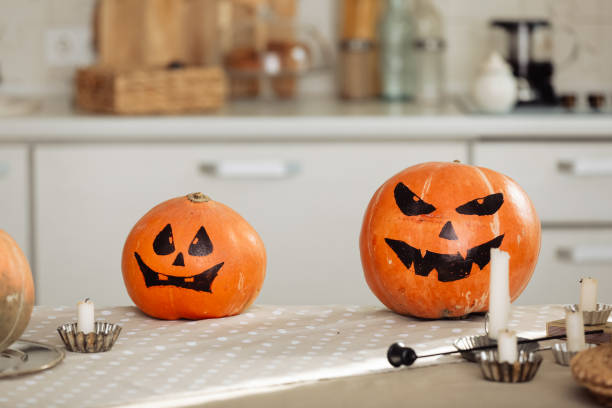 istock Halloween pumpkin head jack lantern with burning candles. illuminated halloween pumpkins with candles in the kitchen. 1282208885