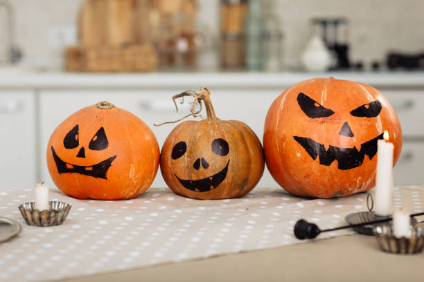 istock Halloween pumpkin head jack lantern with burning candles. illuminated halloween pumpkins with candles in the kitchen. 1282208895
