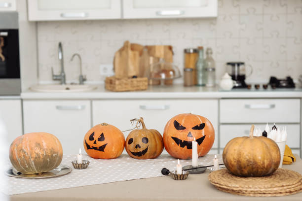 istock Halloween pumpkin head jack lantern with burning candles. illuminated halloween pumpkins with candles in the kitchen. 1282208905
