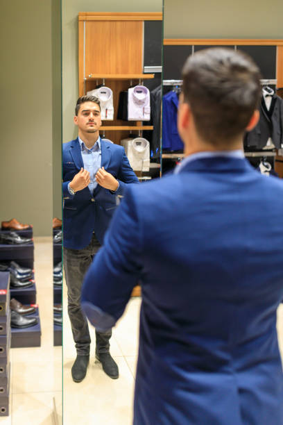 istock Reflection of Young customer smiling while wearing new suit in rental store 1282209203