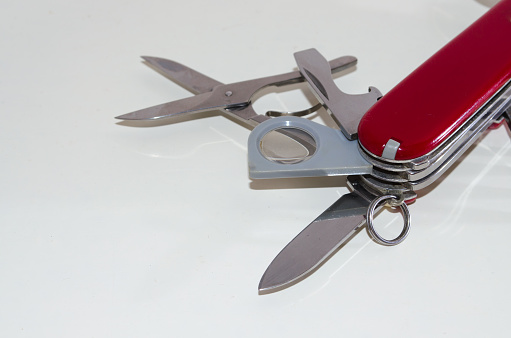 Part of red swiss pocket knife on white background with copy space. Isolated object.