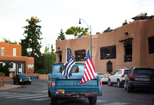 Santa Fe, NM: A pickup truck waving US flags in downtown Santa Fe.