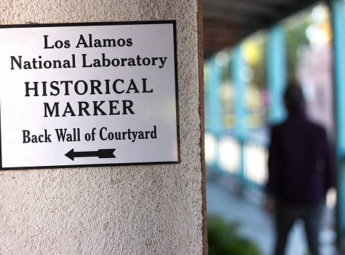 Santa Fe, NM: An arrow pointing to a Los Alamos National Lab historic bronze memorial plaque in downtown Santa Fe.