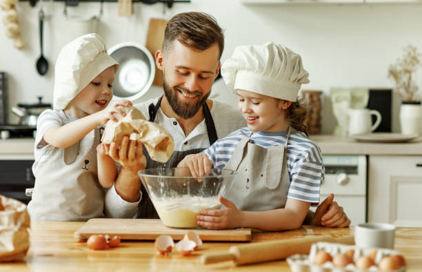istock Father and kids preparing pastry together 1282222567