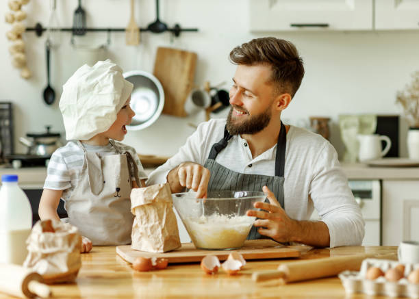 istock Happy man with kid preparing dough at home 1282222581