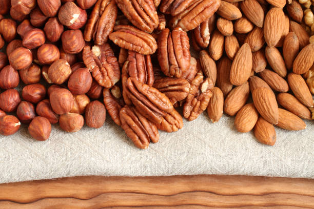 istock Raw peeled hazelnuts, pecans and almonds on a linen cloth. Closeup. Macro 1282224047
