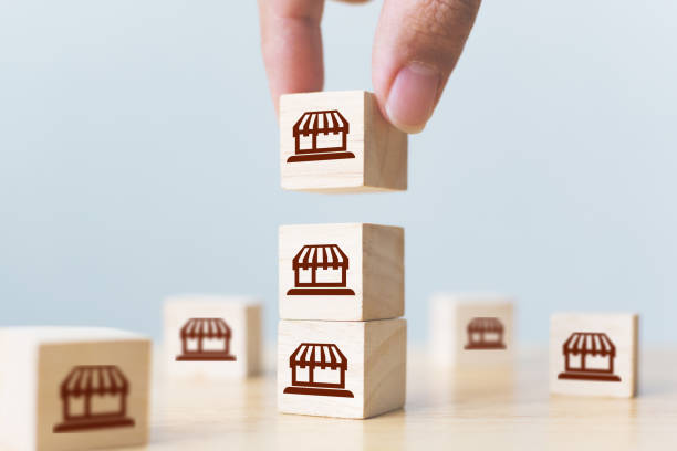 istock Franchise business marketing system concept. Structure service store network strategy. Hand putting wooden block on top with icon store 1282228909