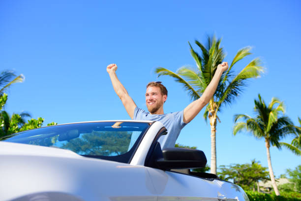 Road trip travel - free man driving car in freedom Road trip travel - free man driving car in freedom. Happy young adult cheering in convertible for his summer vacations convertible photos stock pictures, royalty-free photos & images