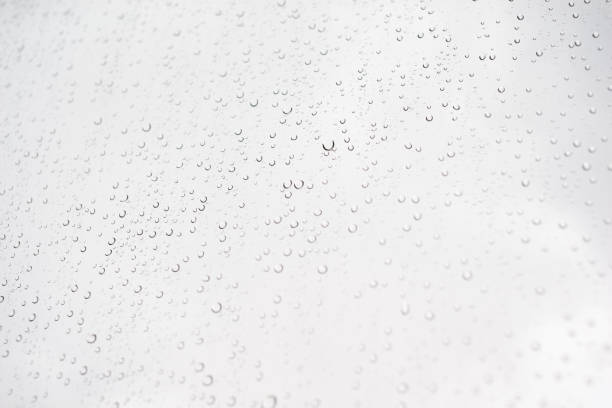 istock Water drop on glass window with cloudy sky on background 1282235892
