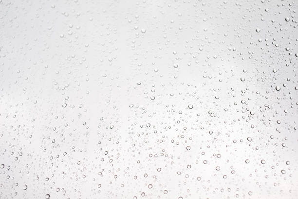 istock Water drop on glass window with cloudy sky on background 1282235907