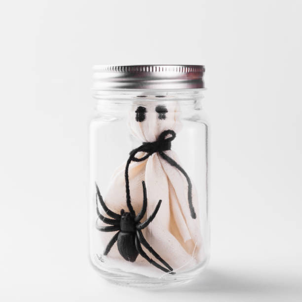 istock The white ghost scary face and black spider in jar glass 1282236966