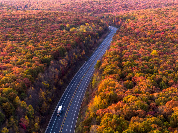 camion conduisant une autoroute dans les montagnes tôt le matin, juste après le coucher du soleil, dans la saison d’automne colorée. - the poconos region photos et images de collection