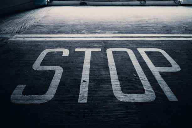 White stop marking sign on road asphalt. Road crossing. Galicia, Spain.