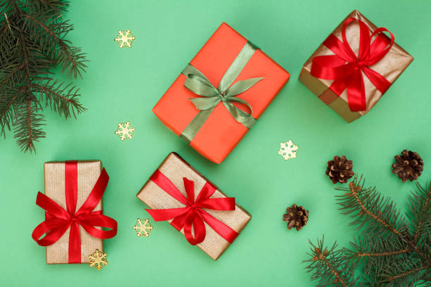 istock Gift boxes, fir tree branches with decorative snowflakes on green background 1282249305