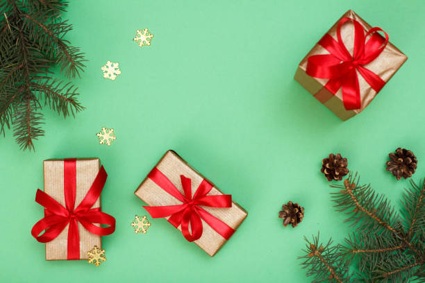 istock Gift boxes, fir tree branches with decorative snowflakes on green background 1282249381