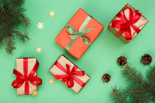 istock Gift boxes, fir tree branches with decorative snowflakes on green background 1282249720