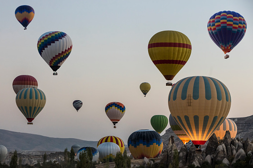 Colorful hot air balloons flying over fairy chimneys in the morning
