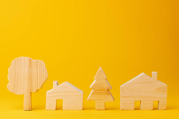 istock Wooden mini house model on yellow background 1282256794