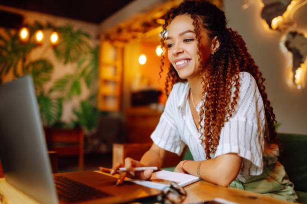 istock Young african american woman working online or studying on laptop computer at restaurant. 1282256888