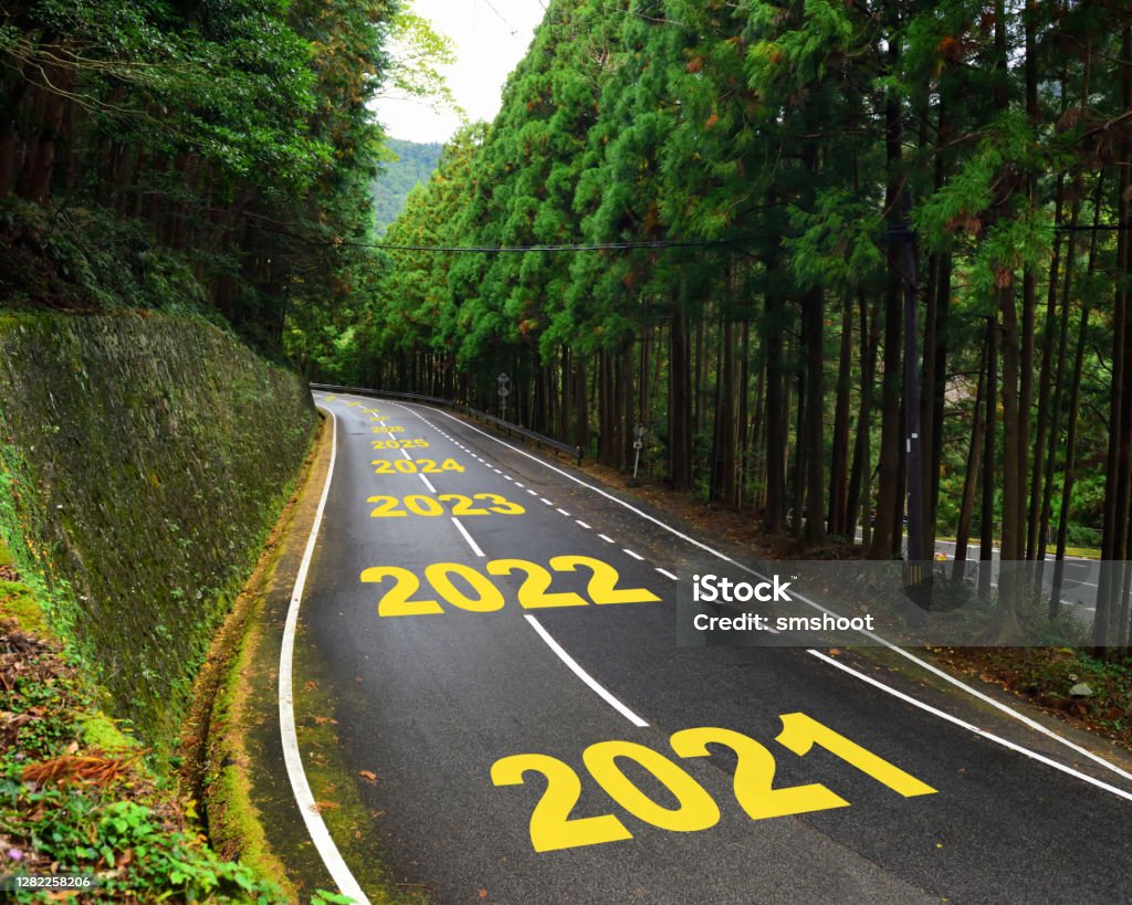 Ten years from 2021 to 2030 on highway road and white marking lines in the forest Happy new year and road to success concept Planning Stock Photo