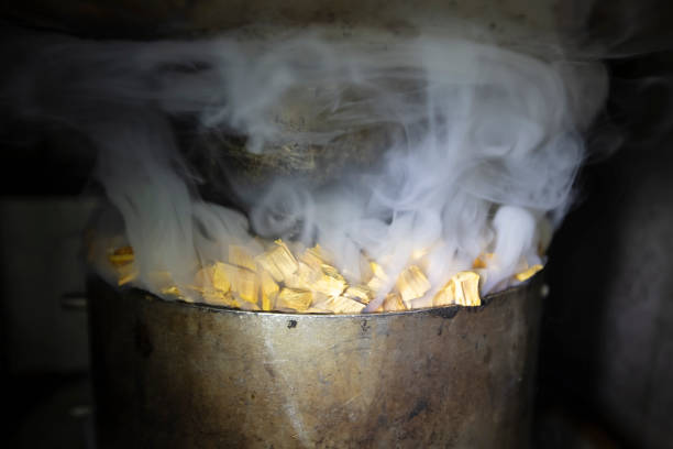 металлический горшок с опилками и дымом в промышленной печи для курения рыбы. - furnaces rheem стоковые фото и изображения