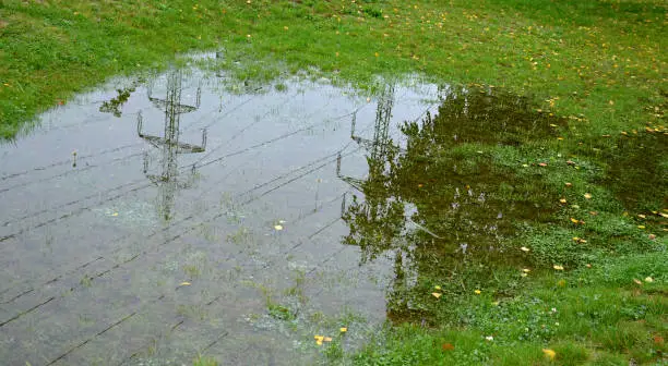 Photo of too compact and impermeable soil does not absorb water during rains and floods. a lake was created in the park in the lawn, which gradually infiltrates. damage to the lawn long flooding. the water pushes the air out of the soil and rots