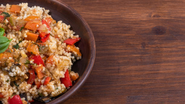 istock Couscous with stewed vegetables is a Moroccan, Algerian and Tunisian dish. Couscous mixed with stewed vegetables in a clay traditional plate, top view, copy space for recipe 1282259877