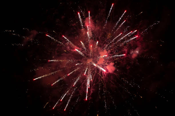istock Red explosion of fireworks with smoke and bokeh on a black background. 1282259943