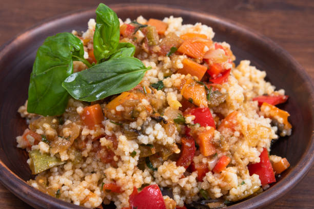 istock Couscous with stewed vegetables is a Moroccan, Algerian and Tunisian dish. Couscous mixed with stewed vegetables in a traditional clay plate 1282259997