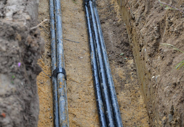istock laying high voltage cables to the ground. the environment does not damage electric poles. Excavation meter deep in the ground black plastic coated strong cable wires. risk of electric shock in case of insulation failure. cover with sand and plastic protec 1282259999