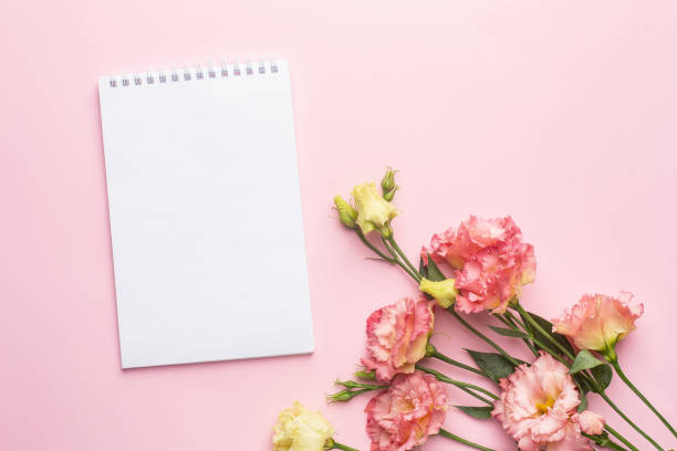istock Notebook and pink flower bouquet on pastel background 1282262092
